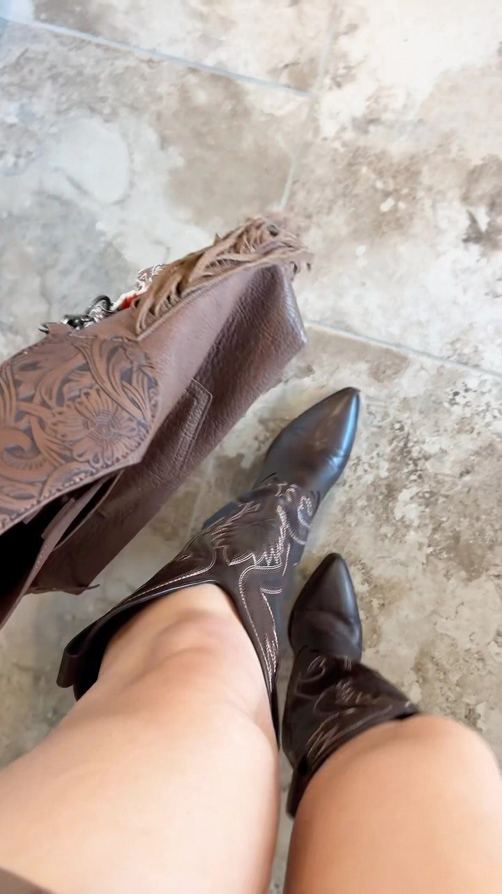 Western Themed Party Outfit Ideas: 8 Looks to Wear 2 Brown pointed-toe cowboy boots with decorative stitching and a fringed leather bag.