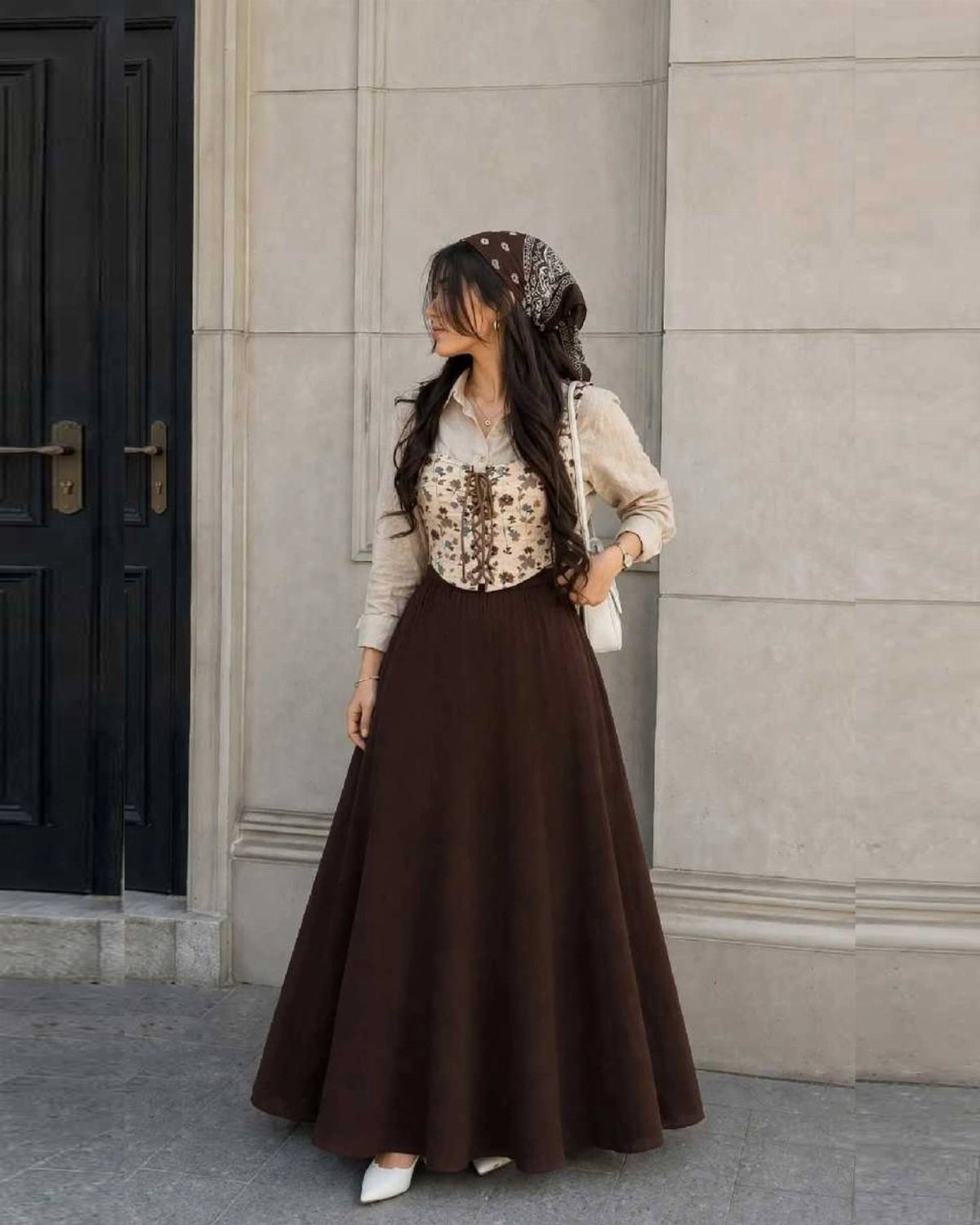 Western Themed Party Outfit Ideas: 8 Looks to Wear 4 Woman wearing a brown flowy maxi skirt and patterned corset vest outdoors.