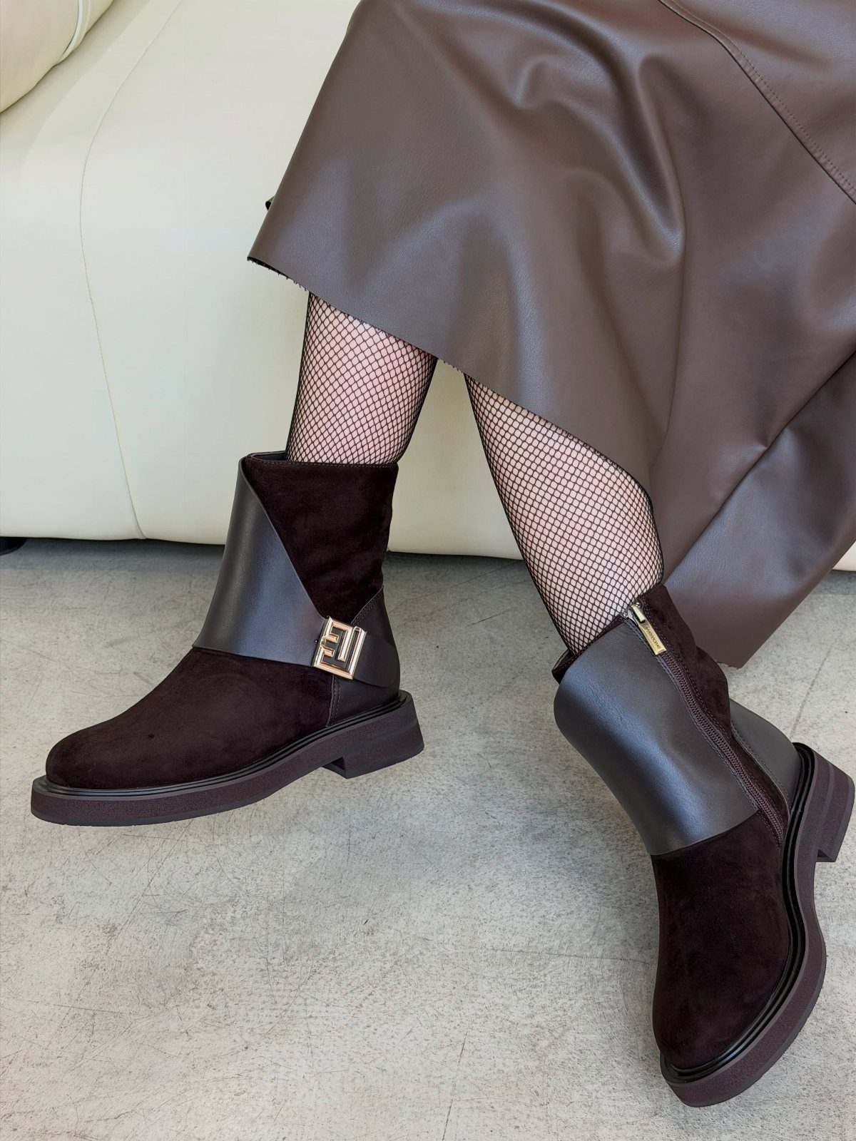 Brown leather midi skirt and dark brown ankle boots with fishnet stockings.