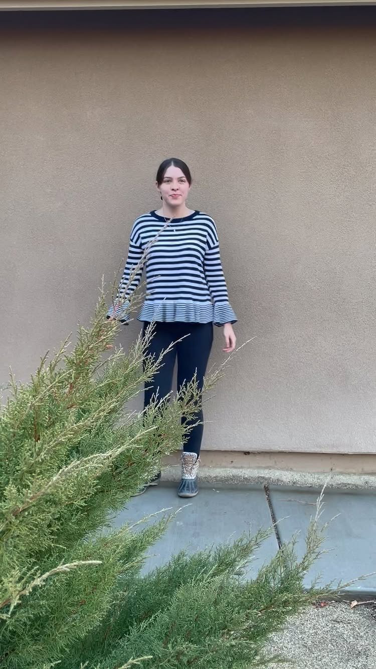 Woman wearing a striped top, black skinny jeans, and grey duck boots outdoors.